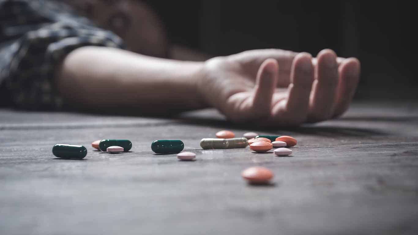 The man committing suicide by overdosing on medication. Close up of overdose pills and addict.