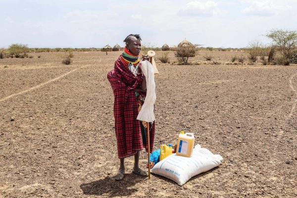 ARCHIVO - Una mujer se ve junto a su racion de comida tras un reparto de ayuda en el poblado de Nalemkais, condado de Turkana, Kenia, el 8 de febrero de 2026. (AP Foto/Patrick Ngugi, Archivo)